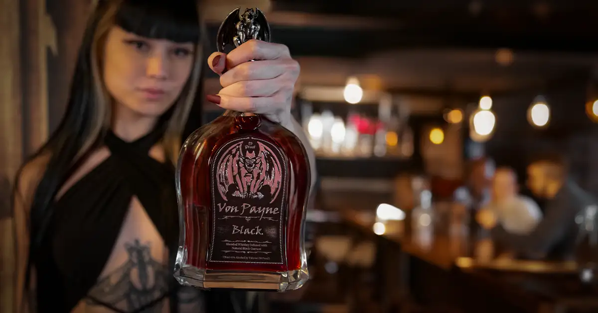 a bartender holding a bottle of von payne whiskey 